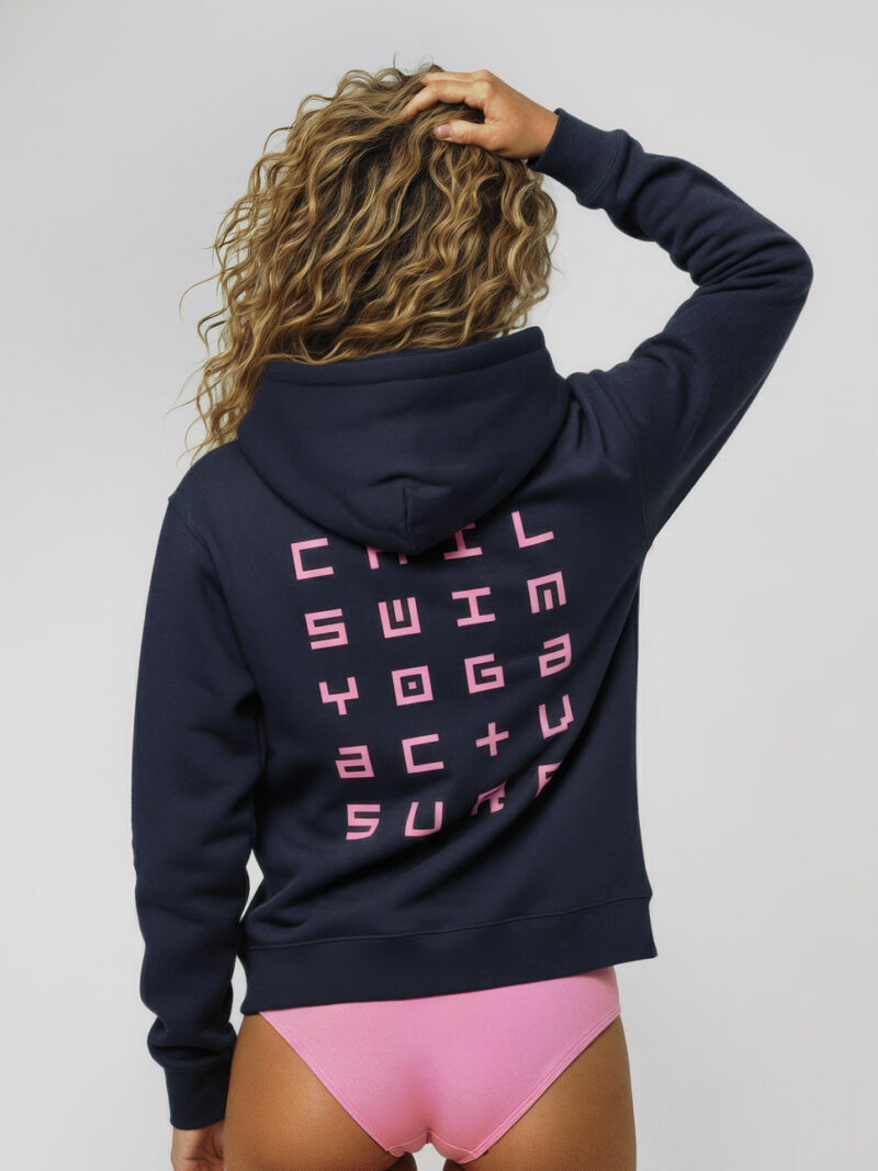 Back view of The Session Hoodie in navy blue, featuring a pink typographic print on the back reading: CHIL, SWIM, YOGA, ACTV, SURF.